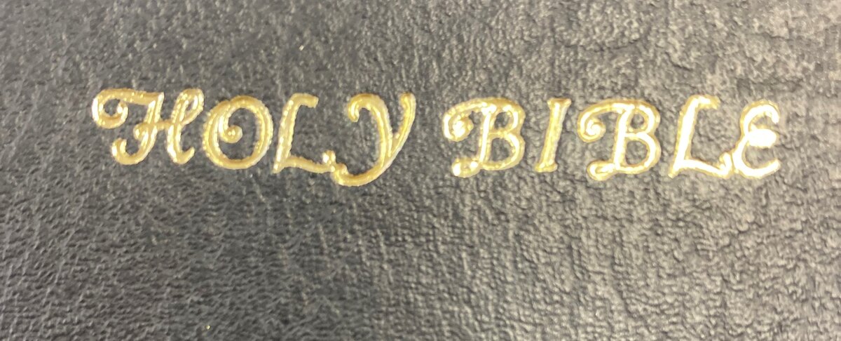 Close-up of decorative gold Holy Bible lettering on a dark cover